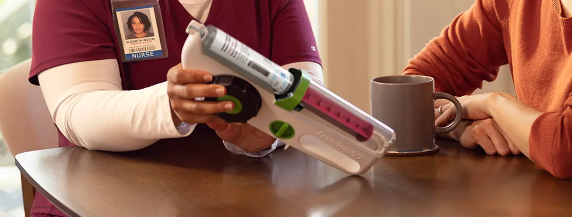 Nurse demonstrating a Hizentra prefilled syringe to a patient, actor portrayal