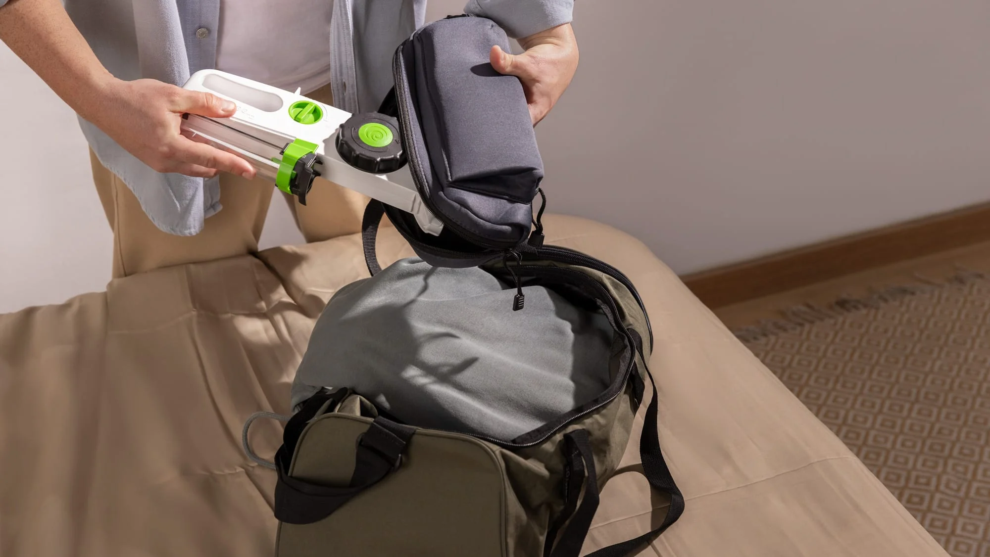 Hands packing a Hizentra self-infusion kit into a travel bag