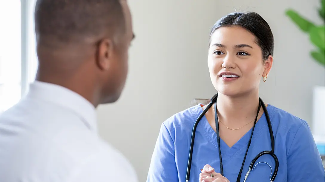 Nurse with a stethoscope talking with a patient about Hizentra self-infusion training, actor portrayal