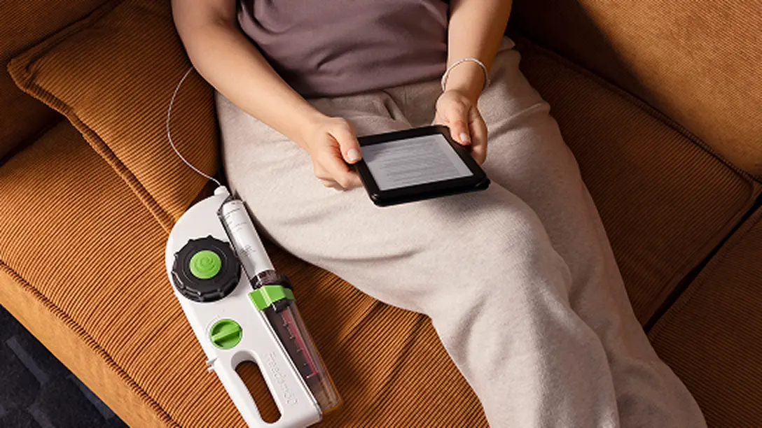 Person using an infusion pump for a Hizentra subcutaneous Ig infusion at home, actor portrayal